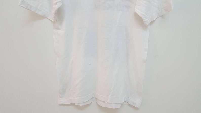 May include: A plain white t-shirt with short sleeves.