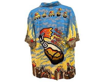 May include: A short-sleeve button-down shirt in light blue with a cloud pattern. The back features a large graphic of a flaming bottle with the text "economic rationalism" and the word "mambo" above it, with a burning city skyline at the bottom.