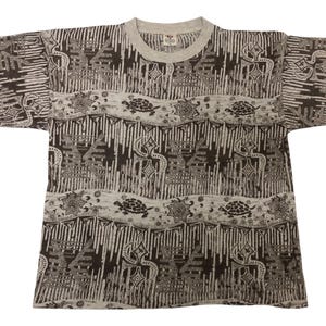 May include: Gray short-sleeved t-shirt with a crew neck. The shirt features a repeating pattern of vertical lines, turtles, and geometric shapes in shades of gray and brown. The overall design has a vintage aesthetic.