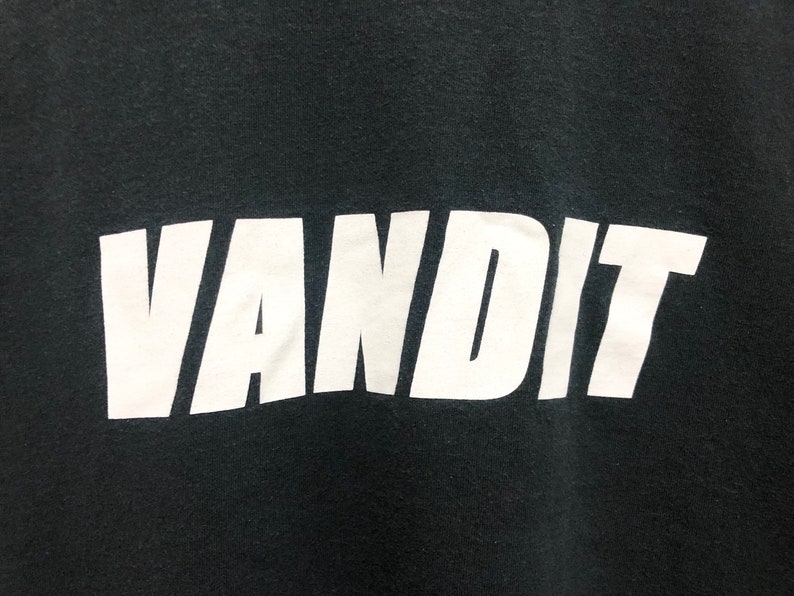 May include: Black t-shirt with the word "VANDIT" printed in white.
