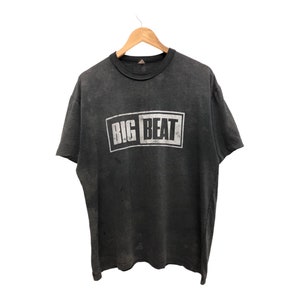 May include: A dark gray t-shirt with a white graphic print of the words "BIG BEAT" in a rectangular box.