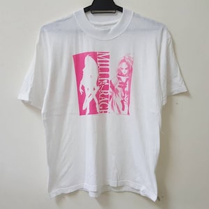 May include: White t-shirt with a pink graphic print of two figures and the text "Mille-Rage!"