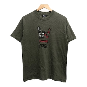 May include: A green t-shirt with a black and red graphic of a hand making the rock and roll sign. The hand is designed with the American flag. The text "FUCT" is printed below the hand.