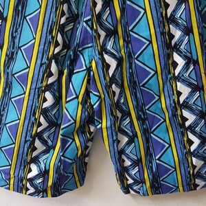 May include: Blue, yellow, and white patterned shorts with a geometric design.