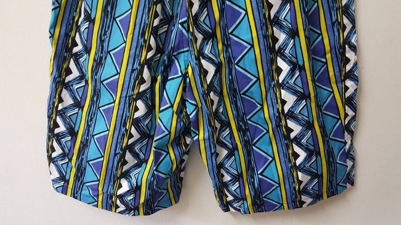 May include: Blue, yellow, and white patterned shorts with a geometric design.