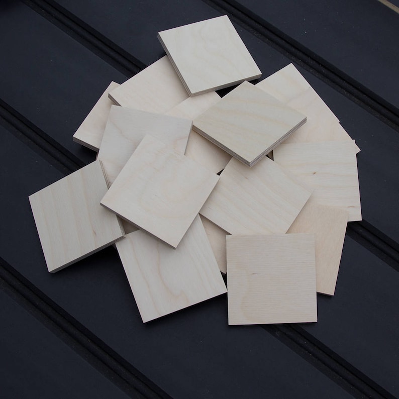Puede incluir: Una pila de 16 bloques de madera cuadrados sin terminar. Los bloques son de madera clara y todos del mismo tama&ntilde;o.