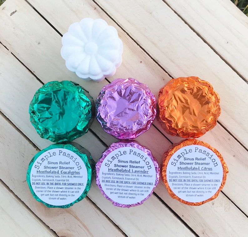 K&ouml;nnte beinhalten: Vier Duschdampfer in Folie verpackt, mit Etiketten mit der Aufschrift "Simple Passion Sinus Relief Shower Steamer Mentholated Eucalyptus", "Simple Passion Sinus Relief Shower Steamer Mentholated Lavender" und "Simple Passion Sinus Relief Shower Steamer Mentholated Citrus".