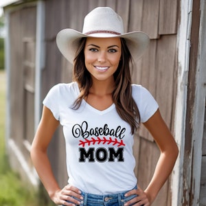 May include: A white t-shirt with a black and red baseball themed graphic that says "Baseball MOM". The shirt is being worn by a person with long brown hair and a white cowboy hat.
