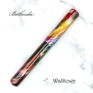 May include: A vibrant pen featuring a swirling pattern in red, yellow, purple, and gold. The pen has a dark base and a rounded tip. The word "Bethesda" is written in cursive at the top, and "Walltown" is at the bottom.
