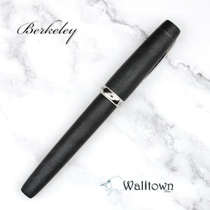 May include: A black pen with a silver band, labeled "Berkeley," rests on a white marble surface. The pen's dark color contrasts with the bright background. The Walltown logo is visible at the bottom.