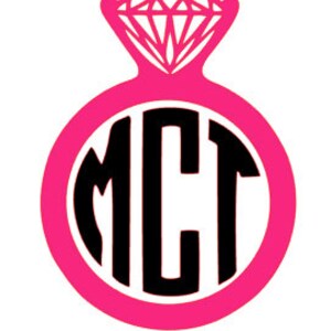 Pode incluir: Anel rosa com um diamante preto e as letras "MCT" em um círculo.