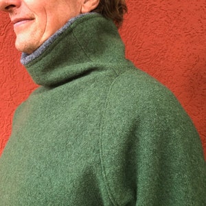Puede incluir: Un su&eacute;ter verde de cuello alto con un cuello gris.