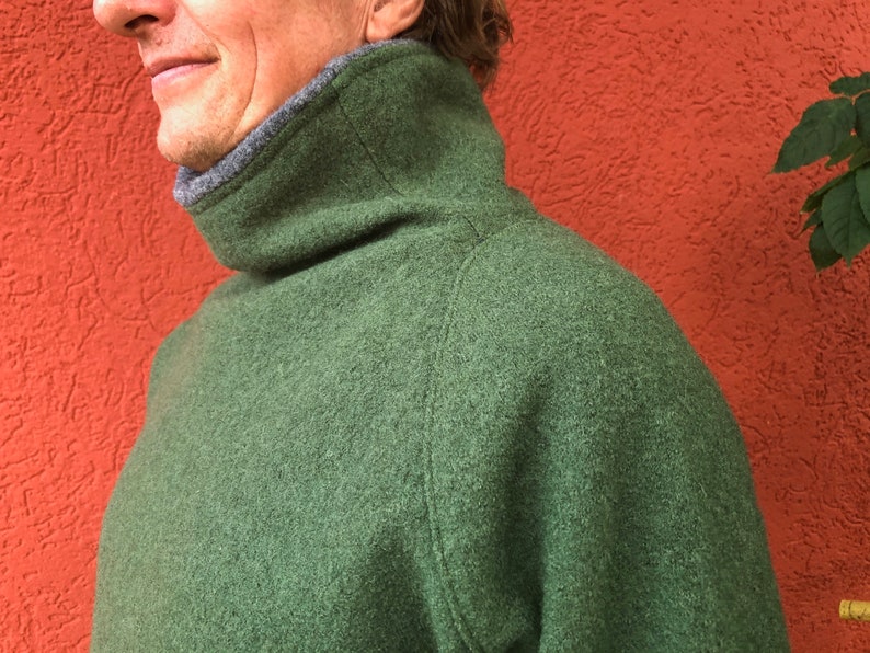 Puede incluir: Un su&eacute;ter verde de cuello alto con un cuello gris.