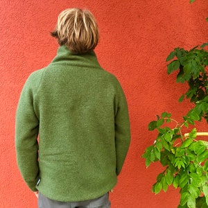 Puede incluir: Una chaqueta de forro polar verde con cuello alto.