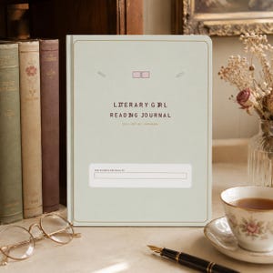 May include: A light sage green hardcover reading journal with gold border lines. The cover features the text "LITERARY GIRL READING JOURNAL" and "READ REFLECT REMEMBER" with a "THIS JOURNAL BELONGS TO" box at the bottom and small icons.