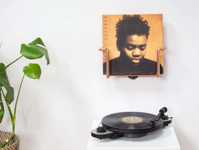 Vinyl record  holder that is wall mounted, ideal for holding up to 15 records. It is made from polished copper pipe, and allows you to flick through your records whilst still displaying the covers.