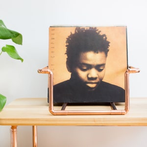 Vinyl record collection holder that is freestanding, ideal for a table top. It is made from polished copper pipe, and allows you to flick through your records whilst still displaying the covers.