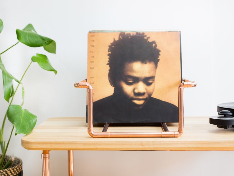 Vinyl record collection holder that is freestanding, ideal for a table top. It is made from polished copper pipe, and allows you to flick through your records whilst still displaying the covers.