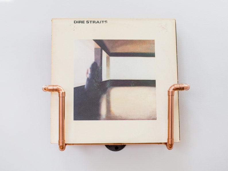 Vinyl record  holder that is wall mounted, ideal for holding up to 15 records. It is made from polished copper pipe, and allows you to flick through your records whilst still displaying the covers.