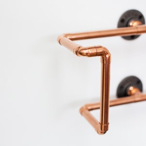 Vinyl record  holder that is wall mounted, ideal for holding up to 15 records. It is made from polished copper pipe, and allows you to flick through your records whilst still displaying the covers.