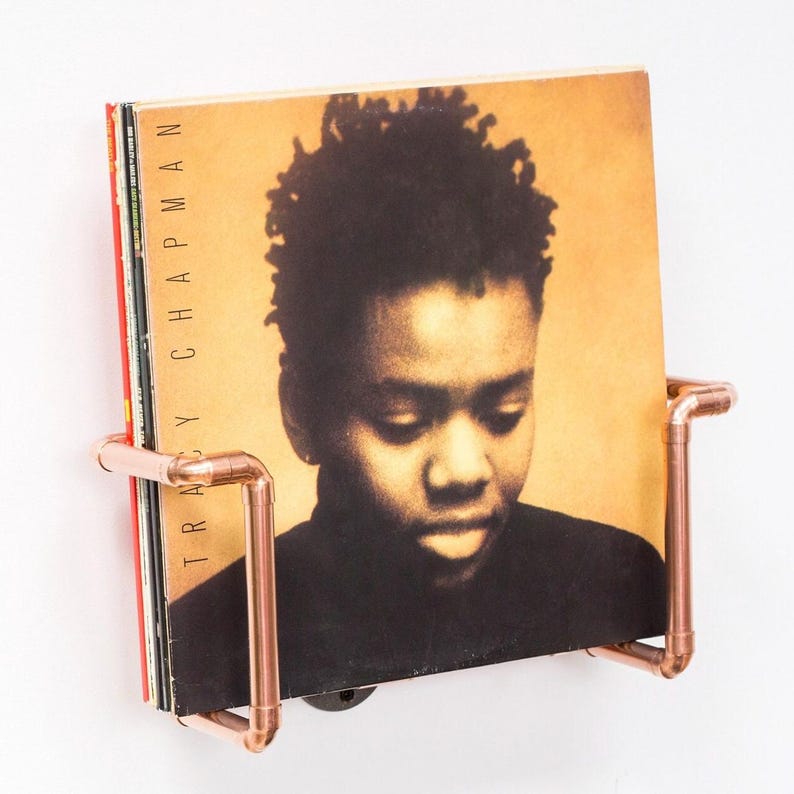 Vinyl record  holder that is wall mounted, ideal for holding up to 15 records. It is made from polished copper pipe, and allows you to flick through your records whilst still displaying the covers.