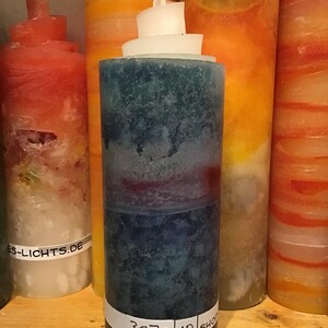 Könnte beinhalten: Eine hohe, blaue, weiße und rote Kerze mit einem weißen Wachsoberteil. Die Kerze hat ein Etikett mit der Aufschrift "3070 10 SHOP".