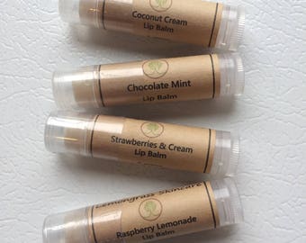 May include: Four lip balm tubes with brown paper labels. The labels have a green tree logo and list the flavors: Coconut Cream, Chocolate Mint, Strawberries & Cream, and Raspberry Lemonade.