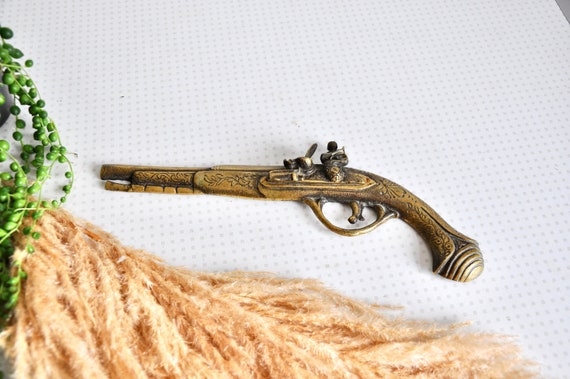 Vintage etched brass gun or pistol ornament for use as boho wall 
