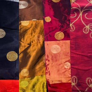 May include: A patchwork fabric with different colors and textures. The fabric is made up of several different pieces of fabric sewn together. The fabric has a variety of colors, including red, orange, brown, and gold. The fabric is decorated with gold embroidery.