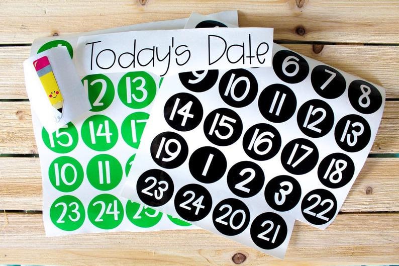 May include: Two sheets of stickers with black and green circles containing numbers from 1 to 25. The text "Today's Date" is printed on the top of the sheet with black circles.
