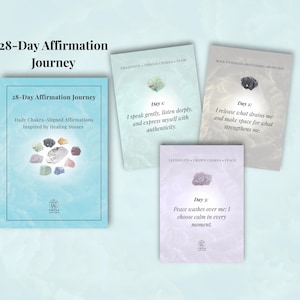 May include: A collection of affirmation cards and a book titled "28-Day Affirmation Journey." The book is light blue with the title and "Daily Chakra-Aligned Affirmations Inspired by Healing Stones." The cards feature affirmations and healing stones.