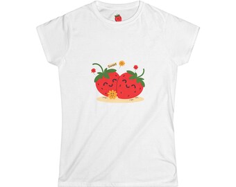 May include: White t-shirt featuring a playful design of two smiling red strawberries with green leaves and a small yellow flower. The word "Sweet" is above the strawberries. A small strawberry is printed on the upper back of the shirt.