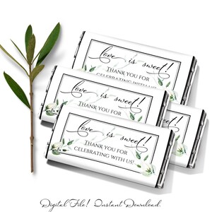May include: Four white chocolate bar wrappers with a black border and green floral design. The text on the wrappers reads "Love is sweet! Thank you for celebrating with us!"