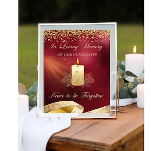 Op de afbeelding: Een ingelijst bord met een rode achtergrond en gouden glitteraccenten. Het bord luidt "In liefdevolle herinnering aan onze klasgenoten Nooit vergeten" en toont een witte kaars met een vlam.