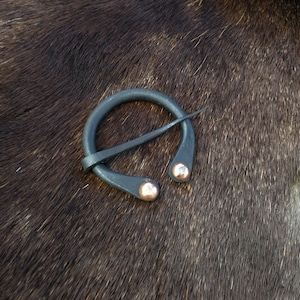 Hand forged viking horseshoe brooch with copper rivets