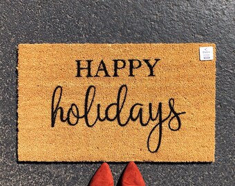 May include: A brown coir doormat with the text "HAPPY holidays" in black lettering.
