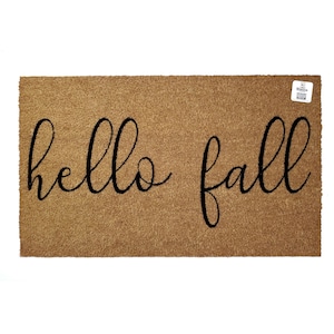 Könnte beinhalten: Eine braune Kokosmatte mit dem Text "hello fall" in schwarzer, kursiv geschriebener Schrift.