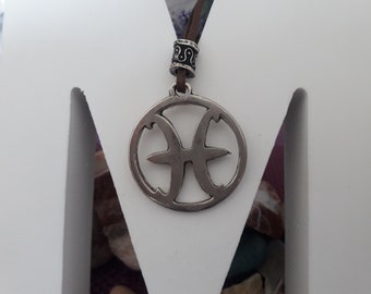 Fiskarnas horoskop läderhalsband med pärla, fisksymbolen stjärntecken, astrologitecken, styrande planeten Neptunus fantasins planet