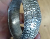 This closed hand hammered pewter bangle.