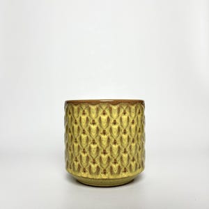 May include: A set of three ceramic mugs with a speckled, matte finish. The mugs are in shades of cream, light gray, and dark gray. Each mug has a simple, modern design and a rounded handle.