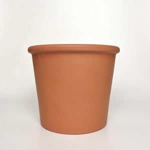 May include: A terracotta-colored plant pot with a rounded rim. The cylindrical pot has a smooth, unglazed surface and a slightly tapered shape. The pot is designed for planting flowers, herbs, or other plants.