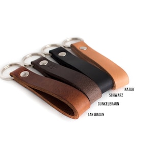 Puede incluir: Llaveros de cuero en varios colores: marr&oacute;n claro, marr&oacute;n oscuro, negro y natural. Cada llavero tiene un anillo de metal plateado y un lazo de cuero asegurado con un remache de metal. Fondo blanco.