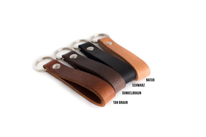 Puede incluir: Llaveros de cuero en varios colores: marr&oacute;n claro, marr&oacute;n oscuro, negro y natural. Cada llavero tiene un anillo de metal plateado y un lazo de cuero asegurado con un remache de metal. Fondo blanco.