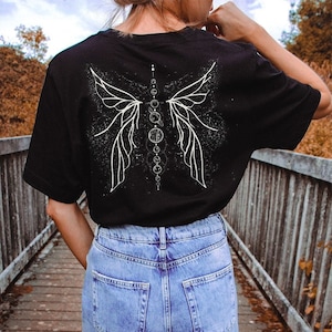 May include: Black t-shirt with a white graphic of a butterfly with a line of circles down the center.