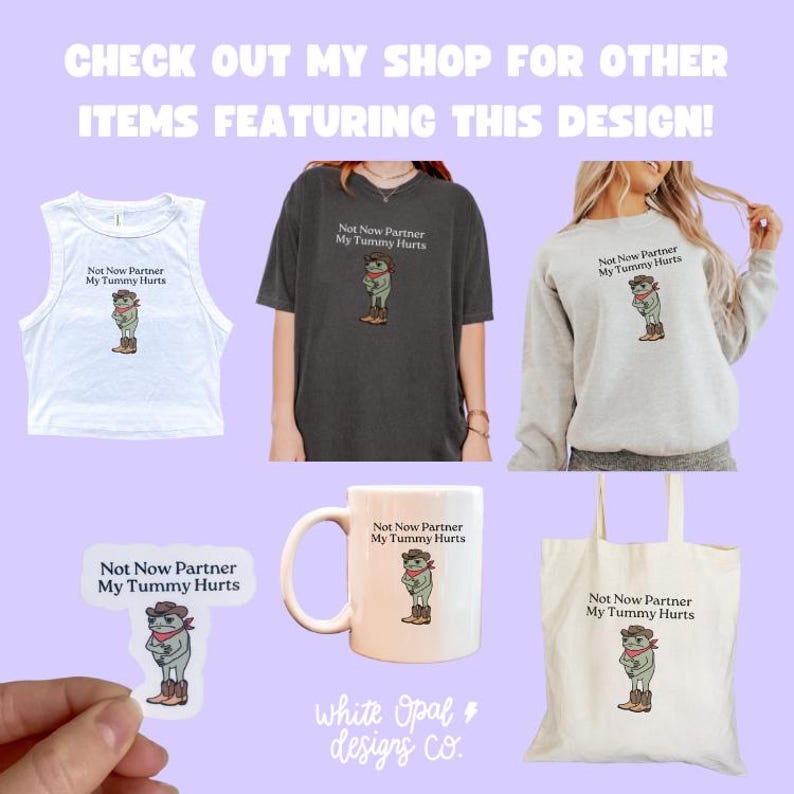 May include: A collection of apparel and accessories featuring a cartoon frog wearing a cowboy hat and boots. Items include a white tank top, a gray t-shirt, a gray sweatshirt, a sticker, a white mug, and a canvas tote bag. The text "Not Now Partner My Tummy Hurts" is displayed on each item.