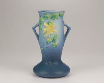 May include: A blue ceramic vase with two handles and a yellow flower design.