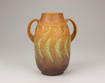 May include: A brown ceramic vase with two handles and a green and brown pea pod design.