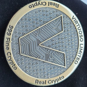 May include: A gold-colored coin with a black and gray design featuring a circuit board pattern and the text "999 Fine Crypto" and "Real Crypto". The coin also has the text "VIRTUOSO LIMITED" on the right side.
