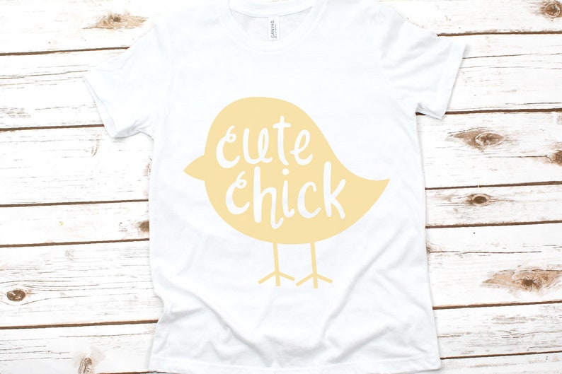 May include: White t-shirt with a yellow chick design and the text "cute chick" printed on it.