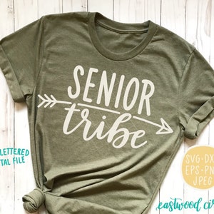 May include: A green t-shirt with the text "SENIOR tribe" in white lettering and an arrow graphic. The text is in a handwritten style font.